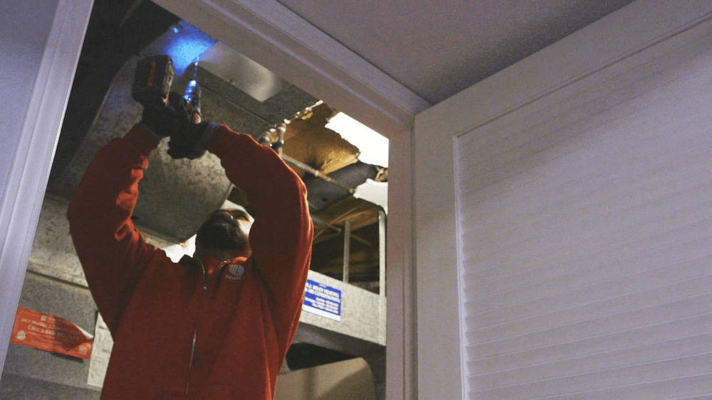 AtlasCare technician working on an air duct